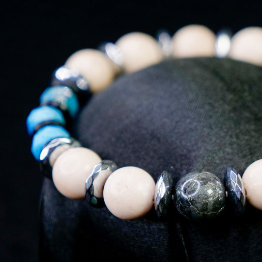 Beaded bracelet with blue and beige beads on a black background